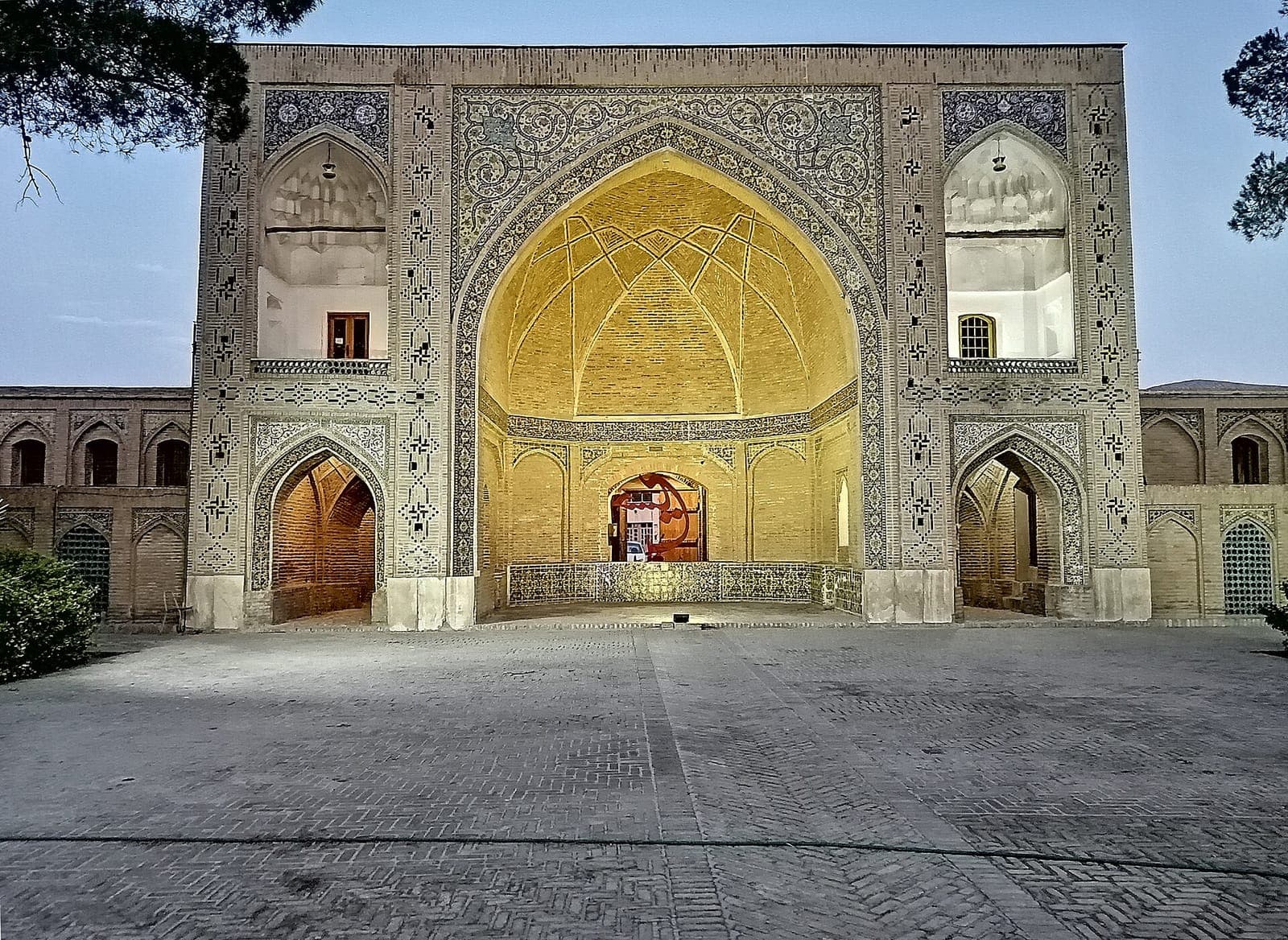 ایوان روشنشدهٔ مسجد امام (سلطانی) سمنان با کاشیکاری معقلی و رسمیبندی آجری در غروب