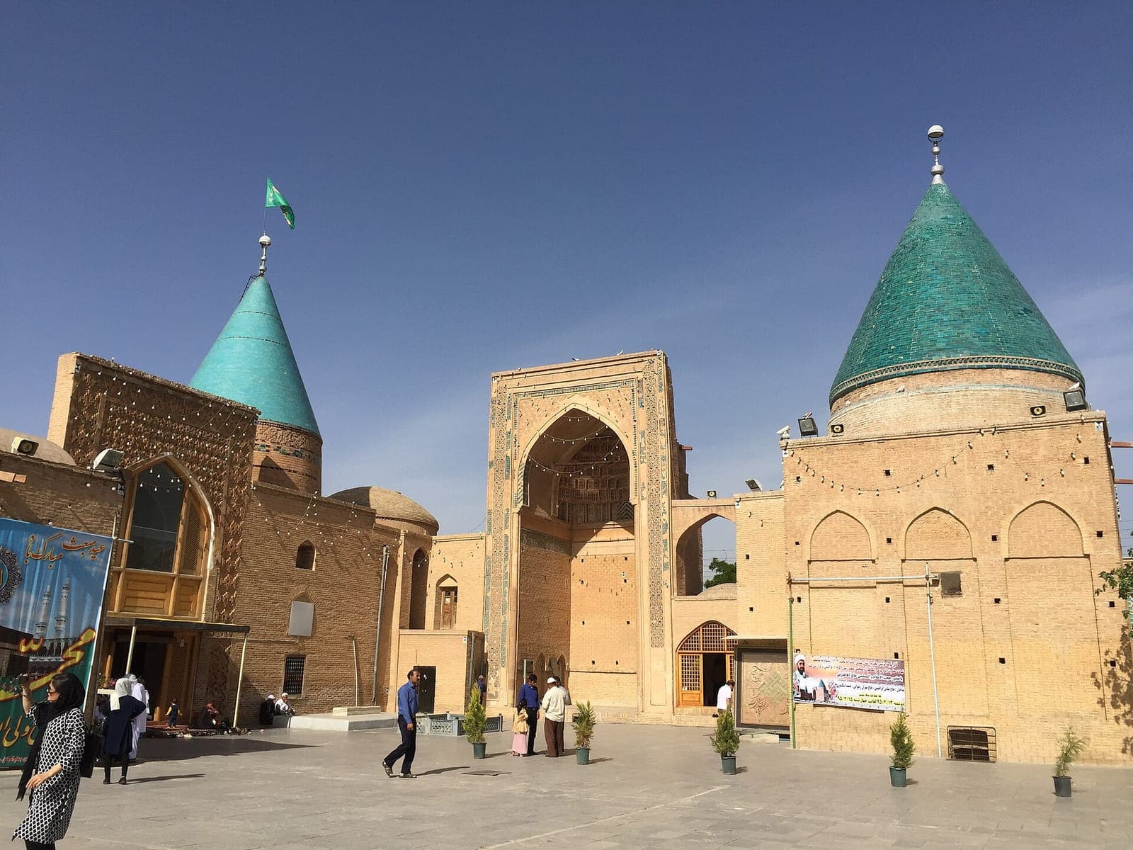 مجموعهٔ تاریخی بایزید بسطامی در بسطام؛ گنبدهای مخروطی فیروزهای و ایوان آجری زیر آسمان آبی