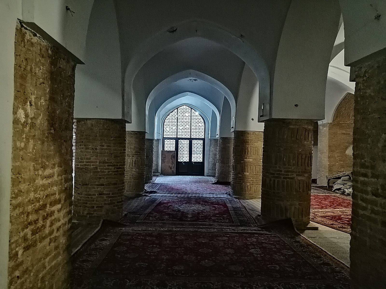 شبستان شرقی مسجد جامع سمنان با ستونهای آجری قطور و فرشهای سرخ